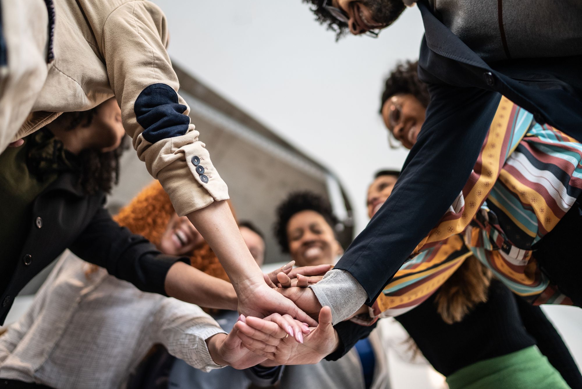 <p>Photo d&#39;un groupe rassemblant leurs mains.</p>